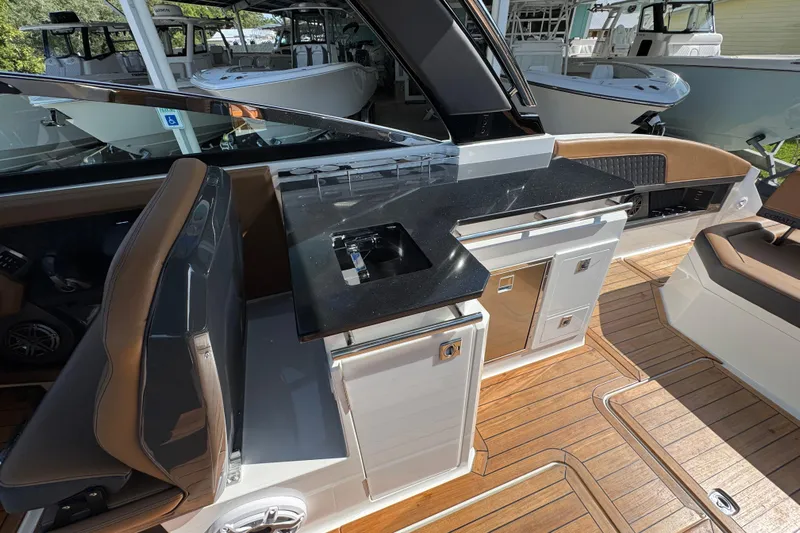  Yacht Photos Pics 2024 Cobalt R33 boat interior with sleek kitchenette and luxurious seating.