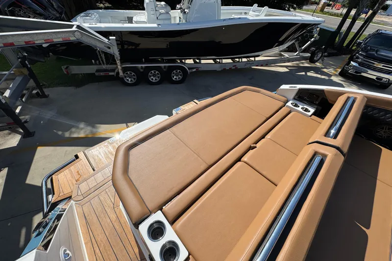  Yacht Photos Pics 2024 Cobalt R33 boat with tan leather seating and wooden deck, parked near a trailer.