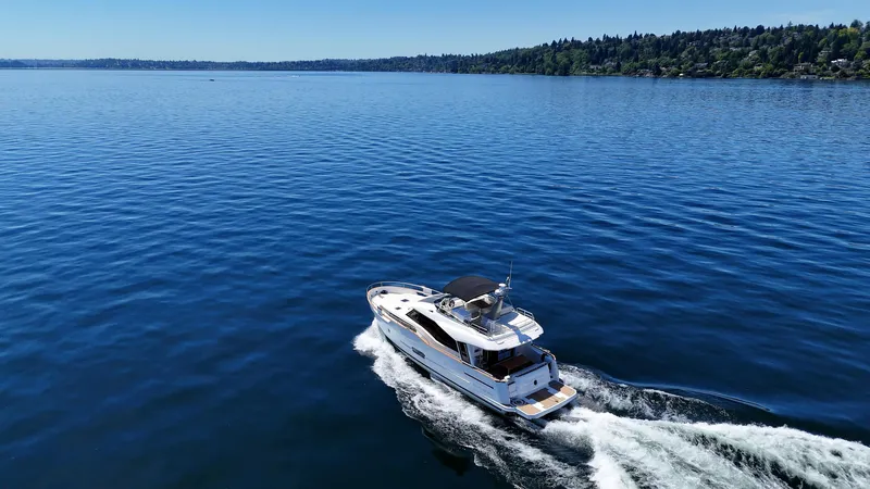  Yacht Photos Pics 2024 Greenline 48 Fly yacht cruising on a serene blue lake.