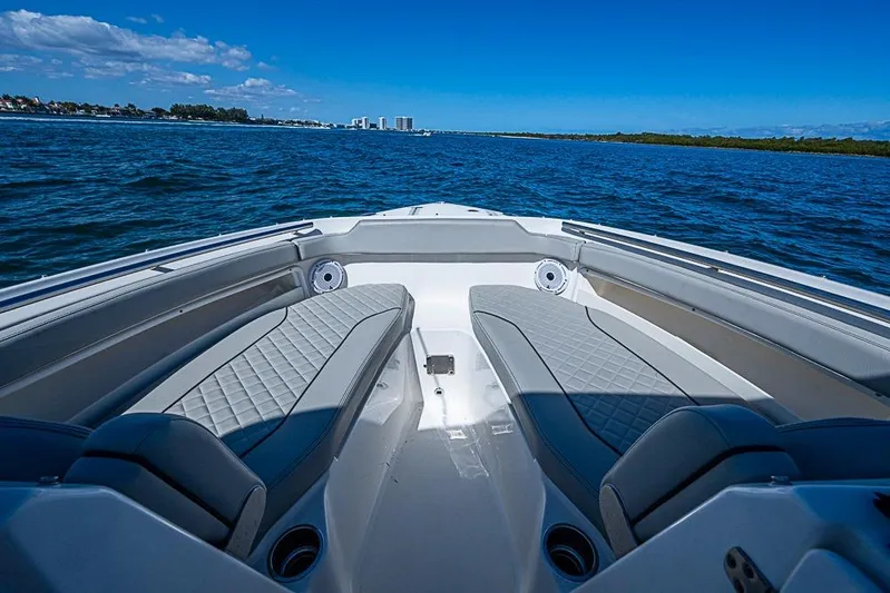 T/t Lucky Seven Yacht Photos Pics 2022 Pursuit DC 266 Dual Console boat interior with cushioned seating on open water.