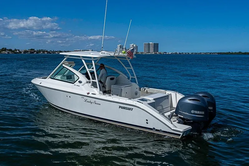 T/t Lucky Seven Yacht Photos Pics 2022 Pursuit DC 266 Dual Console boat cruising on open water under clear skies.