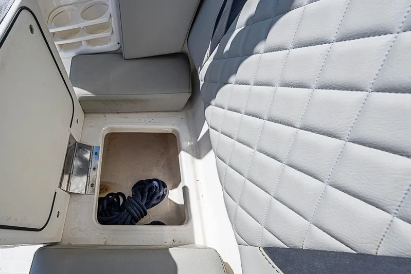 T/t Lucky Seven Yacht Photos Pics 2022 Pursuit DC 266 Dual Console boat storage compartment with coiled rope.