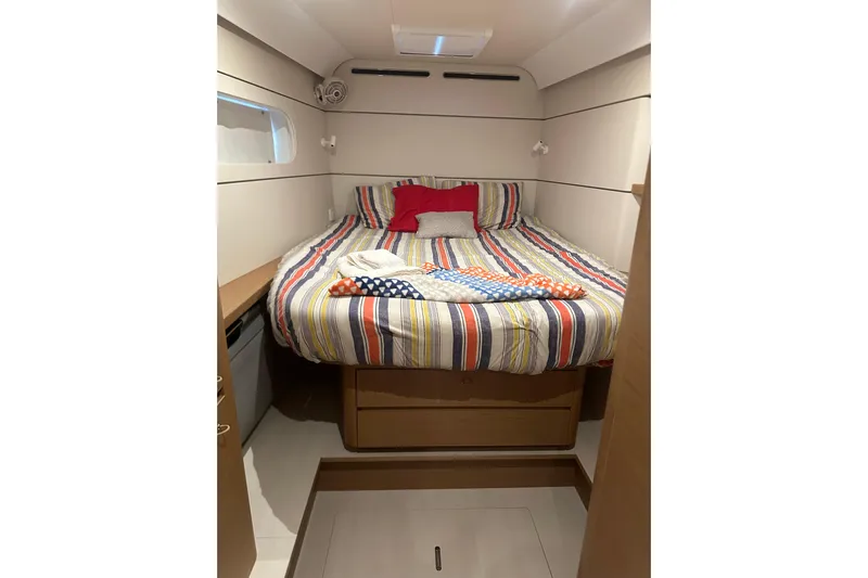  Yacht Photos Pics Cozy cabin interior of 2023 CNB EXCESS 15 with striped bedding and modern design.