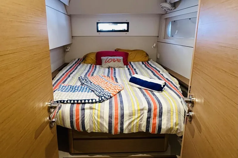  Yacht Photos Pics Cozy bedroom in 2023 CNB EXCESS 15 yacht with striped bedding and decorative pillows.