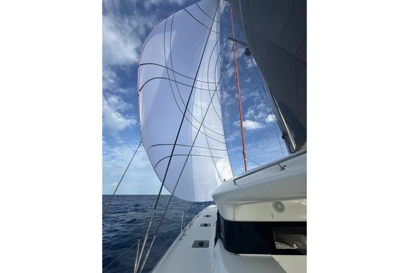  Yacht Photos Pics Sailing on a 2023 CNB EXCESS 15 catamaran with full sails under a blue sky.