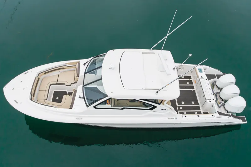  Yacht Photos Pics Aerial view of 2018 Pursuit boat with triple engines on calm water.
