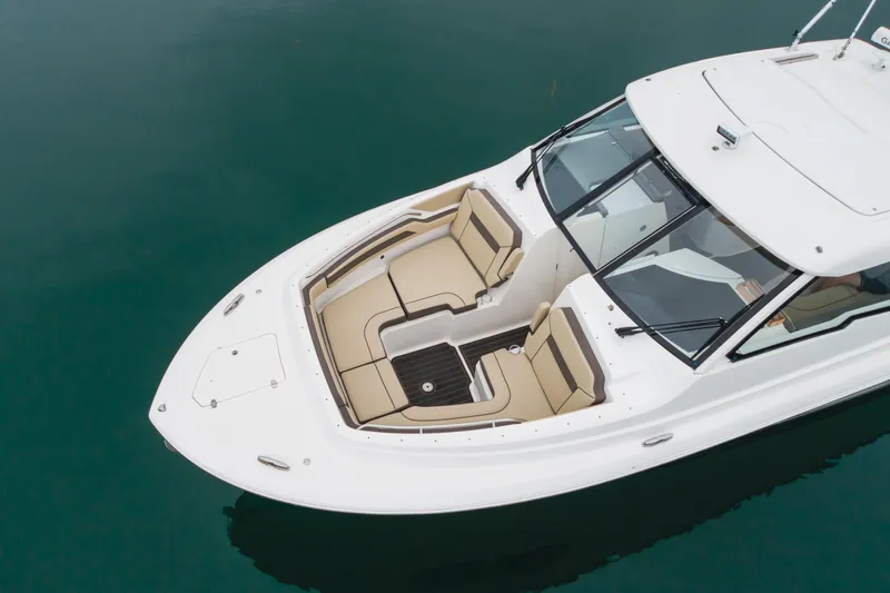  Yacht Photos Pics 2018 Pursuit boat with beige seating, white deck, and sleek design on calm water.