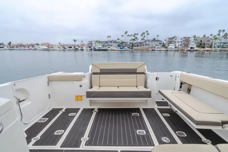  Yacht Photos Pics 2018 Pursuit boat interior with beige seating, overlooking marina and waterfront homes.