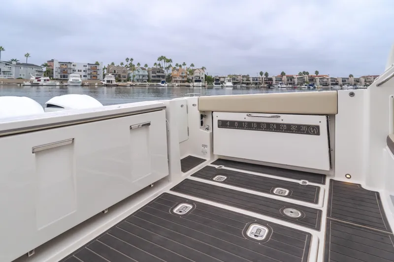  Yacht Photos Pics 2018 Pursuit boat interior with sleek design, overlooking waterfront homes and calm waters.
