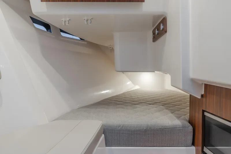  Yacht Photos Pics 2018 Pursuit boat interior cabin with cushioned bed and modern design.