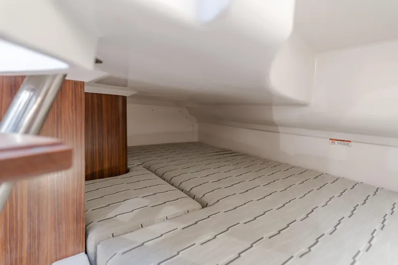  Yacht Photos Pics 2018 Pursuit boat interior with cozy sleeping area and wooden accents.