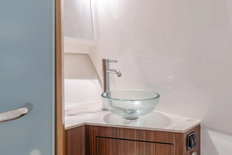 Yacht Photos Pics Modern boat bathroom with glass vessel sink and wooden cabinetry, Pursuit 2018 model.