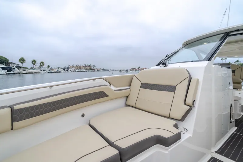  Yacht Photos Pics Luxurious 2018 Pursuit boat with beige seating, docked in a marina.