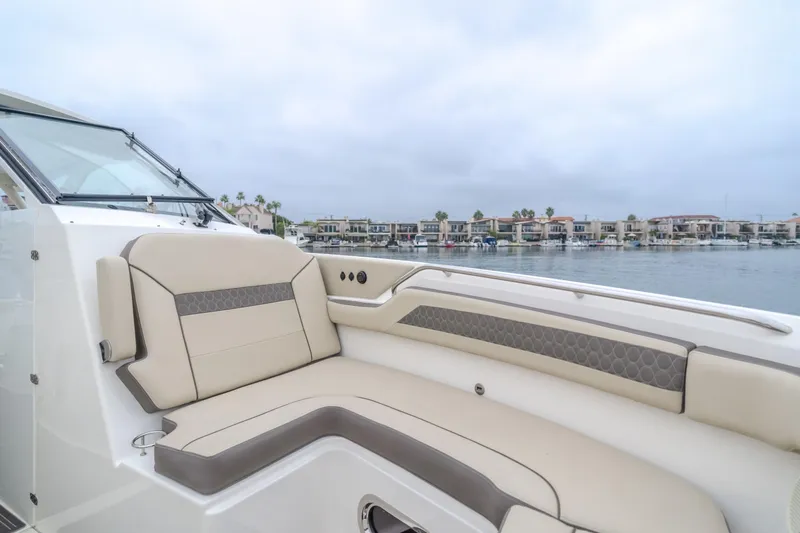  Yacht Photos Pics Luxurious 2018 Pursuit boat interior with beige seating, overlooking waterfront homes.