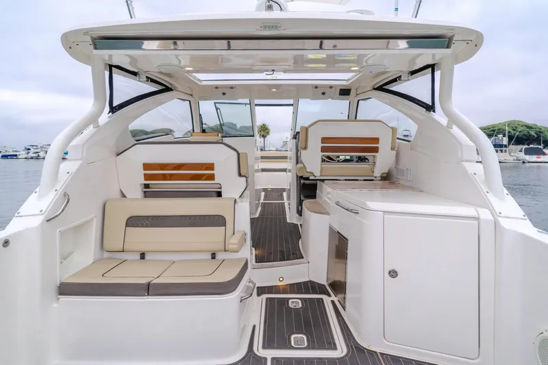  Yacht Photos Pics 2018 Pursuit boat interior with seating and cabinetry, docked in a marina.