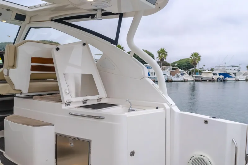  Yacht Photos Pics 2018 Pursuit boat interior with open storage, docked at marina with palm trees.