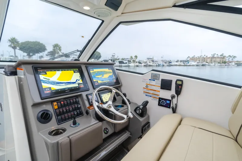  Yacht Photos Pics Interior of a 2018 Pursuit boat with navigation screens and steering wheel.