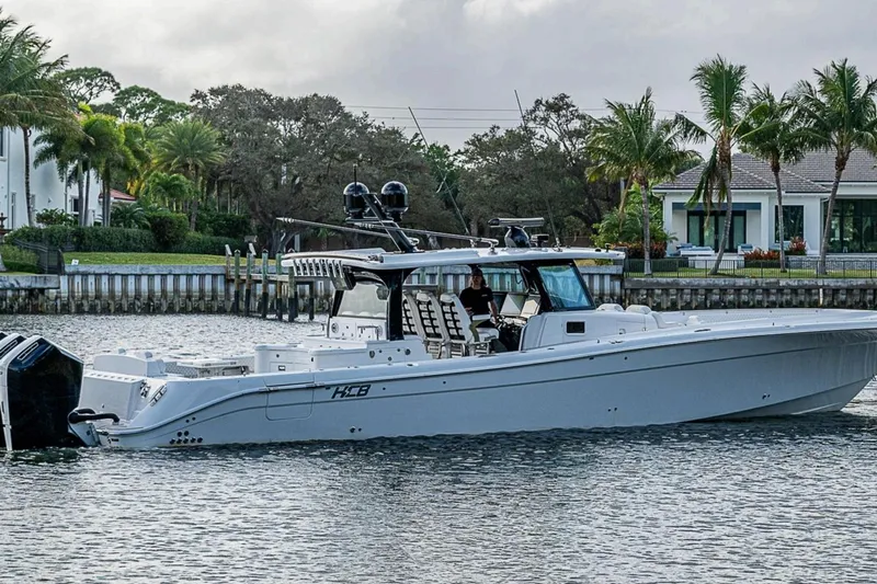 Best Deal Yacht Photos Pics 2023 HCB 53 Suenos RXV boat cruising near waterfront homes and palm trees.