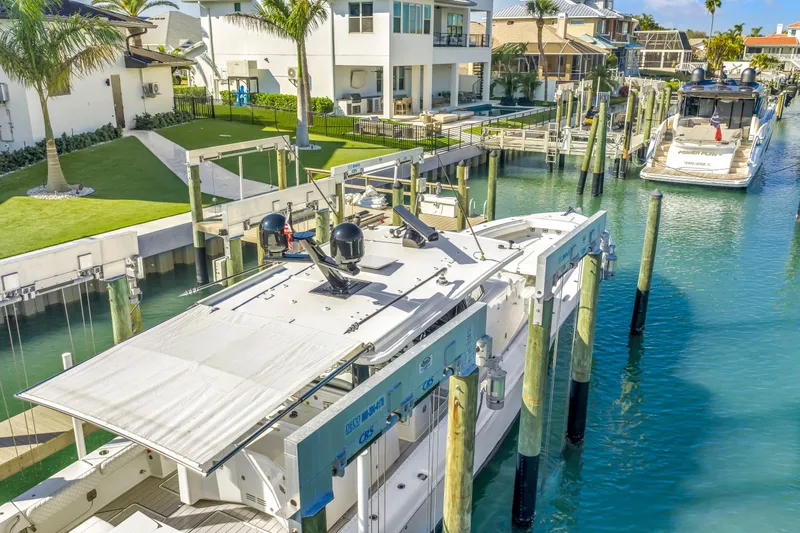 Best Deal Yacht Photos Pics 2023 HCB 53 Suenos RXV docked in a scenic waterfront marina.