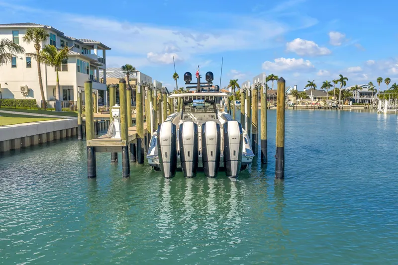 Best Deal Yacht Photos Pics 2023 HCB 53 Suenos RXV docked in a scenic marina with palm trees.