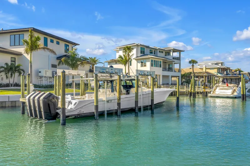 Best Deal Yacht Photos Pics 2023 HCB 53 Suenos RXV boat docked in a scenic waterfront marina.