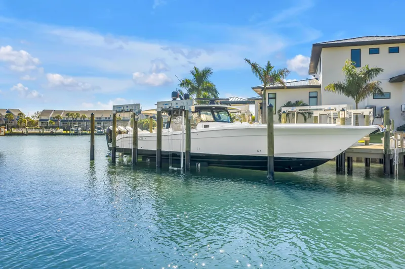 Best Deal Yacht Photos Pics 2023 HCB 53 Suenos RXV boat docked in a scenic waterfront setting.