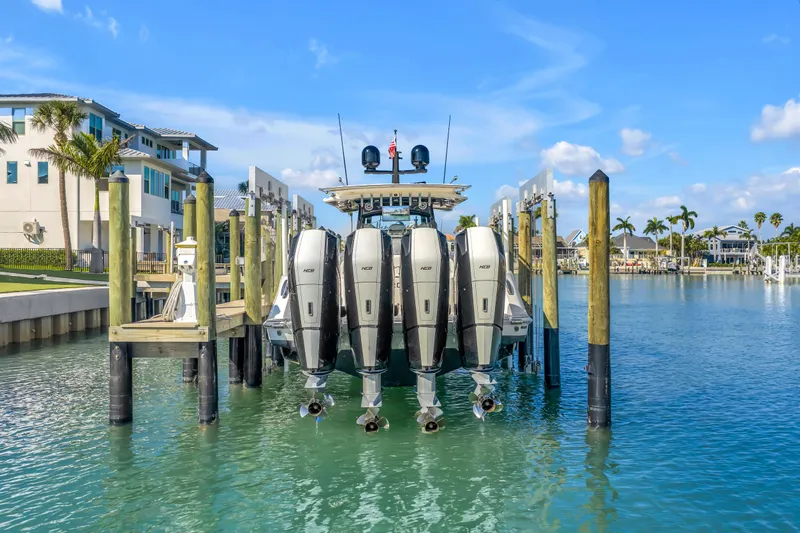 Best Deal Yacht Photos Pics 2023 HCB 53 Suenos RXV boat docked with four powerful engines, surrounded by waterfront homes.