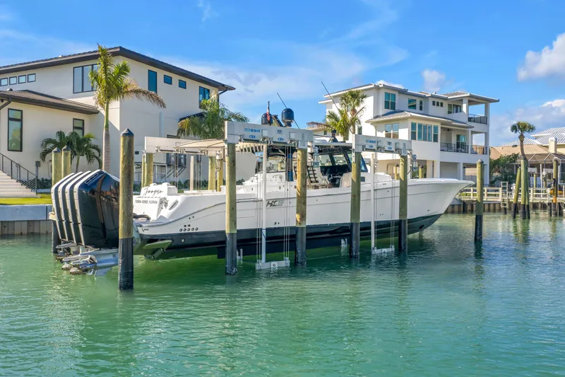 Best Deal Yacht Photos Pics 2023 HCB 53 Suenos RXV boat docked near waterfront homes.