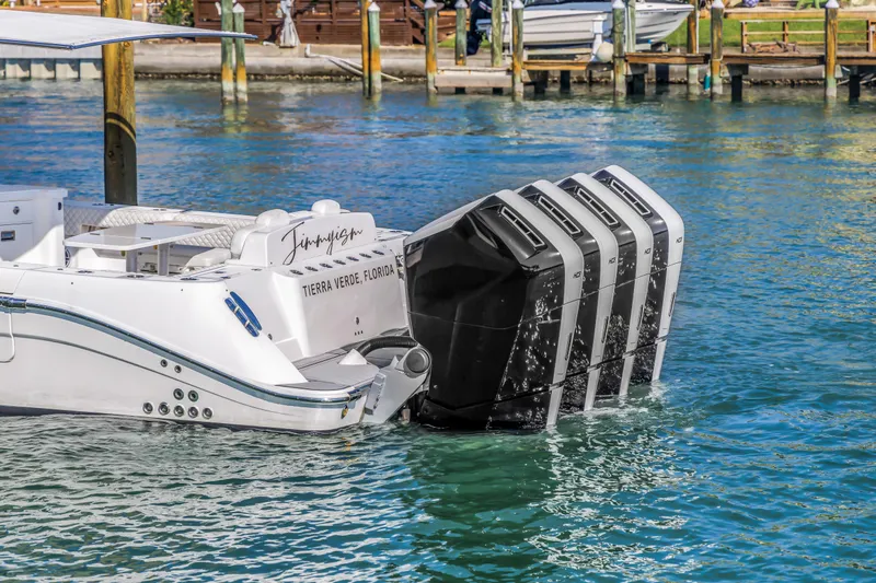 Best Deal Yacht Photos Pics 2023 HCB 53 Suenos RXV boat with four powerful outboard engines docked in clear water.