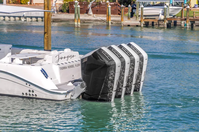 Best Deal Yacht Photos Pics 2023 HCB 53 Suenos RXV boat with four powerful outboard engines docked in clear water.