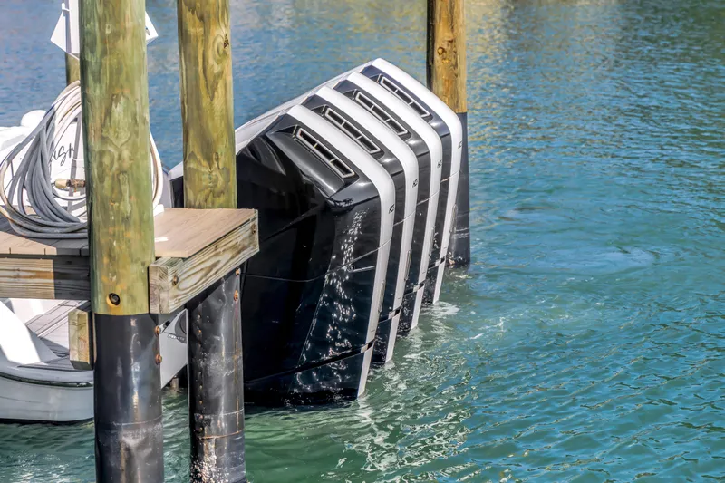 Best Deal Yacht Photos Pics Four powerful outboard motors on a 2023 HCB 53 Suenos RXV docked in clear water.
