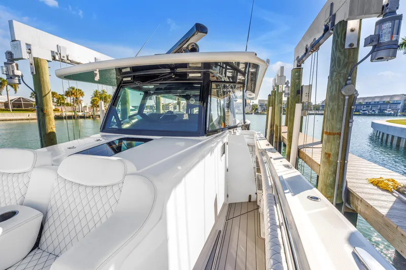 Best Deal Yacht Photos Pics 2023 HCB 53 Suenos RXV luxury boat docked in a sunny marina.