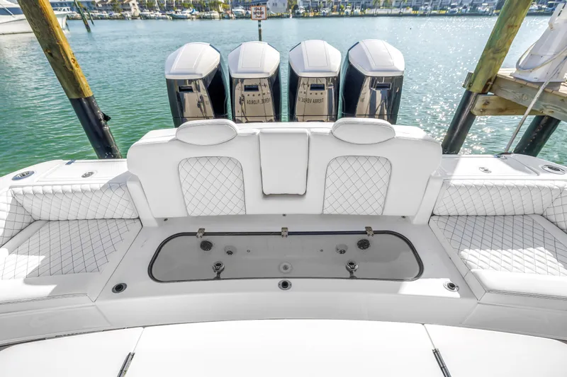 Best Deal Yacht Photos Pics 2023 HCB 53 Suenos RXV boat with luxurious seating and powerful engines docked by the water.