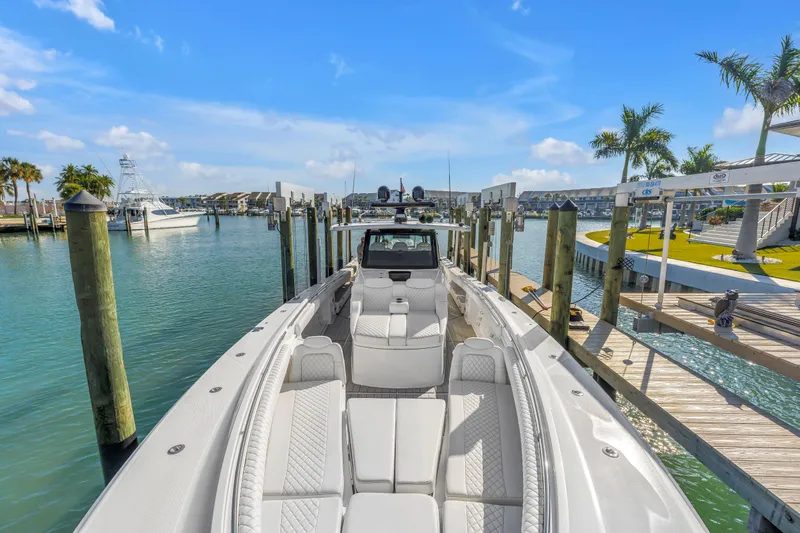 Best Deal Yacht Photos Pics 2023 HCB 53 Suenos RXV luxury boat docked in a sunny marina setting.