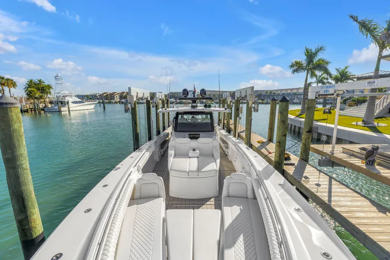 Best Deal Yacht Photos Pics 2023 HCB 53 Suenos RXV luxury boat docked in a sunny marina setting.