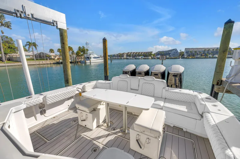 Best Deal Yacht Photos Pics 2023 HCB 53 Suenos RXV luxury boat interior with seating and table, docked by waterfront.