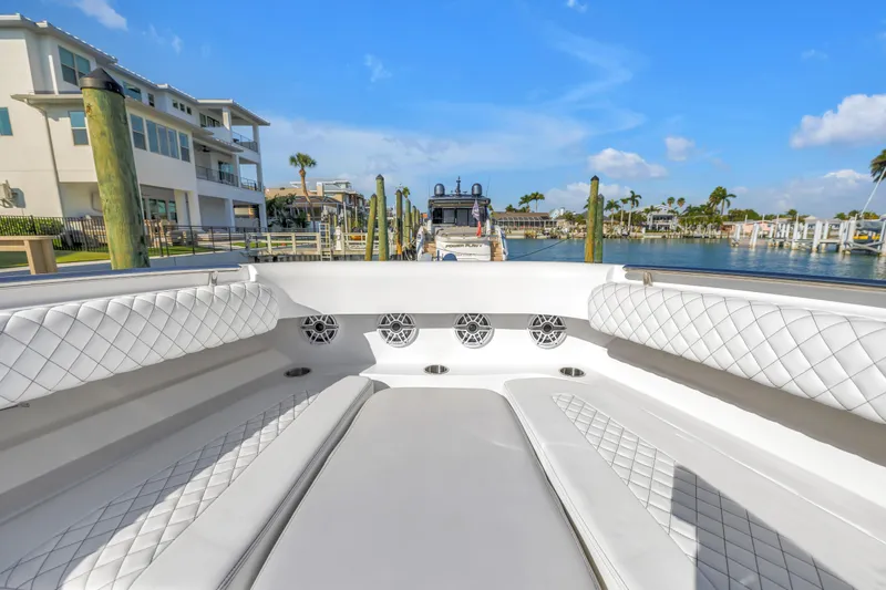 Best Deal Yacht Photos Pics 2023 HCB 53 Suenos RXV luxury boat interior with quilted seating, docked in a sunny marina.