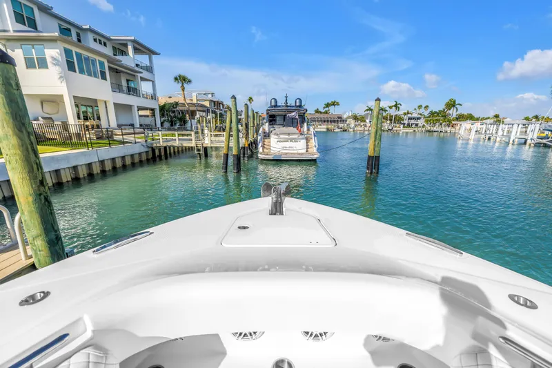 Best Deal Yacht Photos Pics 2023 HCB 53 Suenos RXV yacht docked in a scenic marina with waterfront homes.