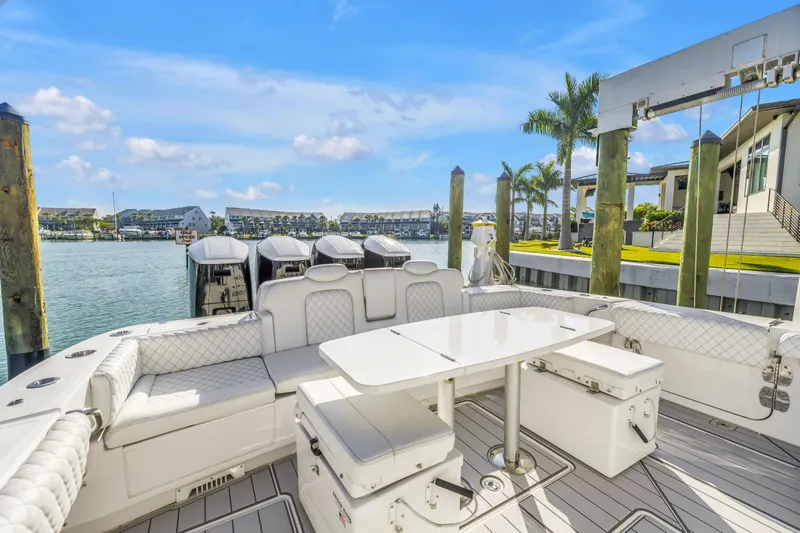 Best Deal Yacht Photos Pics 2023 HCB 53 Suenos RXV luxury boat interior with seating and table, docked by waterfront homes.