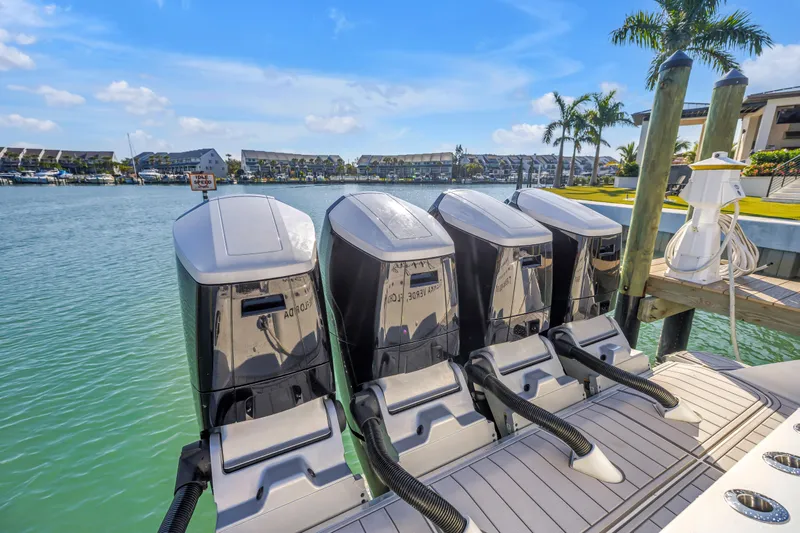 Best Deal Yacht Photos Pics 2023 HCB 53 Suenos RXV boat with four powerful outboard engines docked by the water.