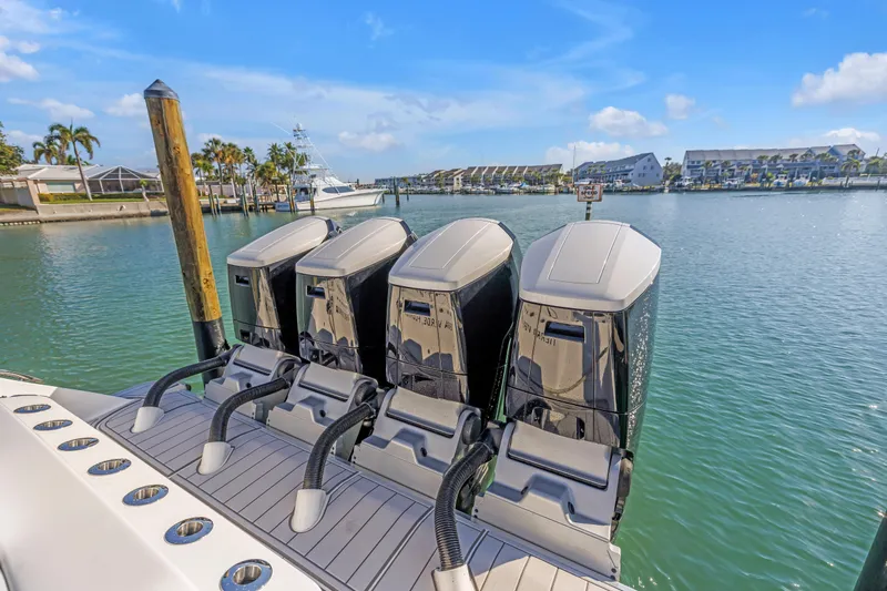 Best Deal Yacht Photos Pics 2023 HCB 53 Suenos RXV boat with four powerful outboard engines docked in a marina.