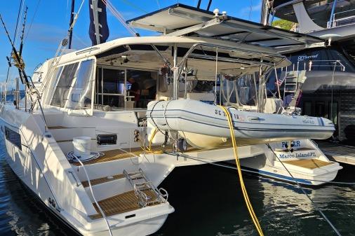 2015 Leopard 48 yacht docked with inflatable boat, sunny day, marina setting.