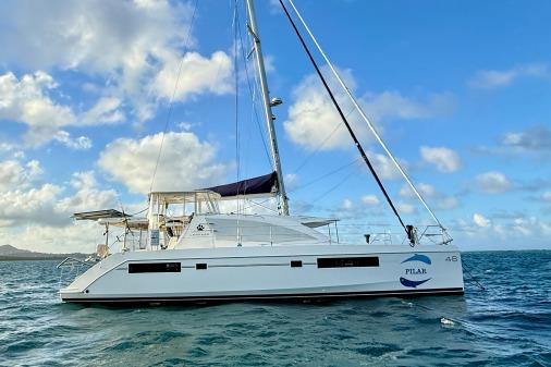 2015 Leopard 48 catamaran sailing on open water under a partly cloudy sky.