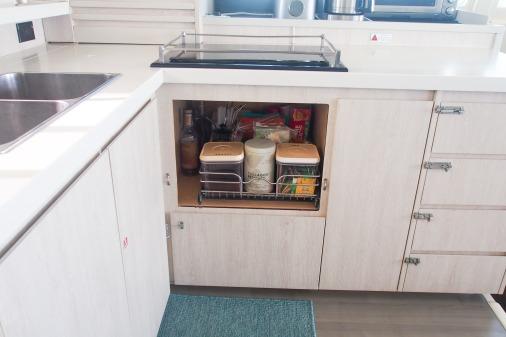 Modern kitchen storage in a 2015 Leopard 48 yacht, featuring organized pantry shelves.