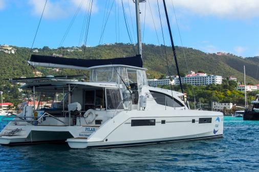 2015 Robertson & Caine Leopard 48 catamaran sailing in a scenic coastal area.