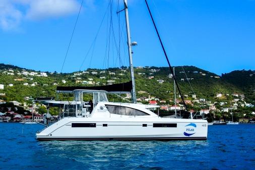 2015 Robertson & Caine Leopard 48 catamaran sailing in a scenic coastal area.