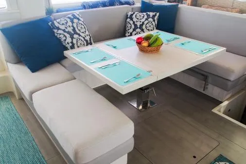 Pilar Yacht Photos Pics 2015 Robertson & Caine Leopard 48 yacht interior with dining area, blue accents, and fruit basket centerpiece.