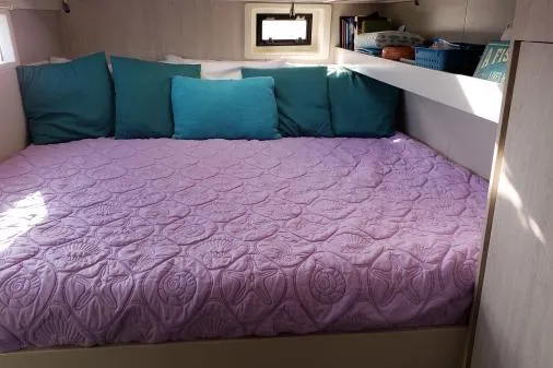 Pilar Yacht Photos Pics Cozy cabin bed in 2015 Robertson & Caine Leopard 48 yacht with purple quilt and teal pillows.