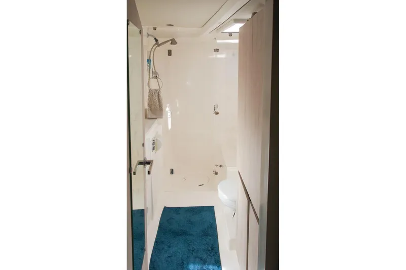 Pilar Yacht Photos Pics Bathroom interior of 2015 Robertson & Caine Leopard 48 yacht, featuring shower and blue mat.