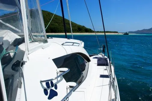 Pilar Yacht Photos Pics 2015 Robertson & Caine Leopard 48 sailing in clear blue waters near a scenic coastline.